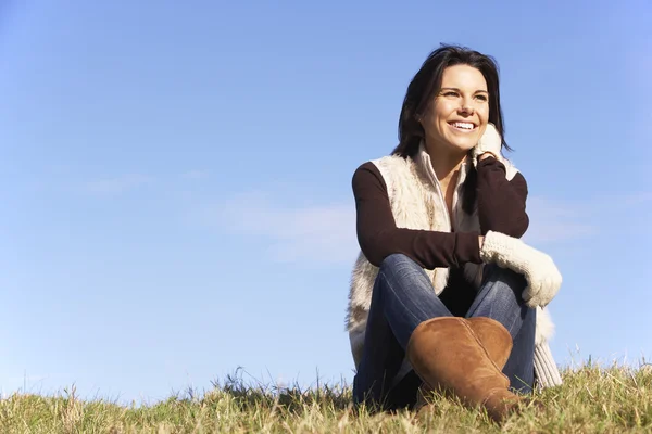 Junge Frau sitzt im Park — Stockfoto