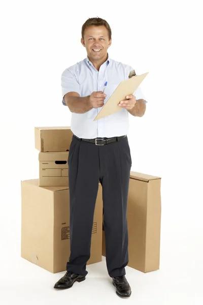 Retrato de mensajero de pie junto a los paquetes, sosteniendo un clipboar —  Fotos de Stock