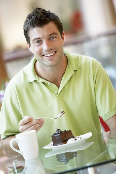 Άνθρωπος τρώει ένα κομμάτι κέικ στο εμπορικό κέντρο — Φωτογραφία Αρχείου