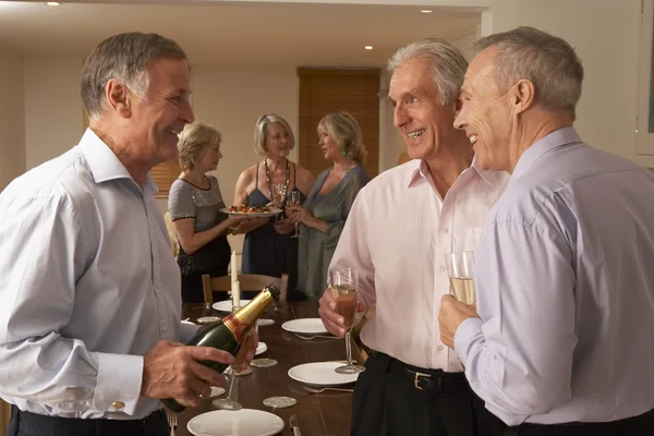 Mann serviert seinen Gästen bei einer Dinnerparty Champagner — Stockfoto