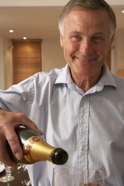 Mann schenkt ein Glas Champagner ein — Stockfoto