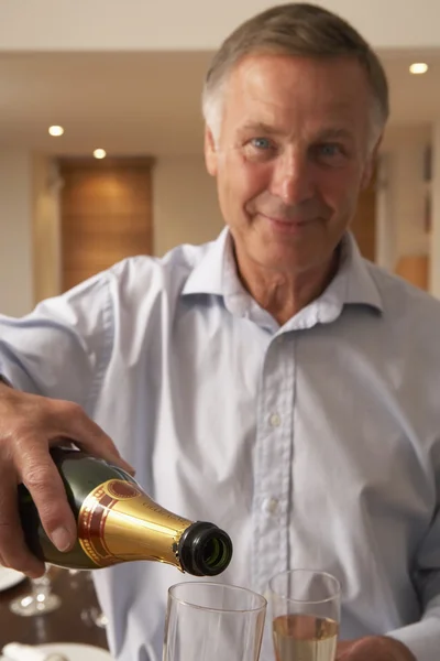 Mann schenkt ein Glas Champagner ein — Stockfoto