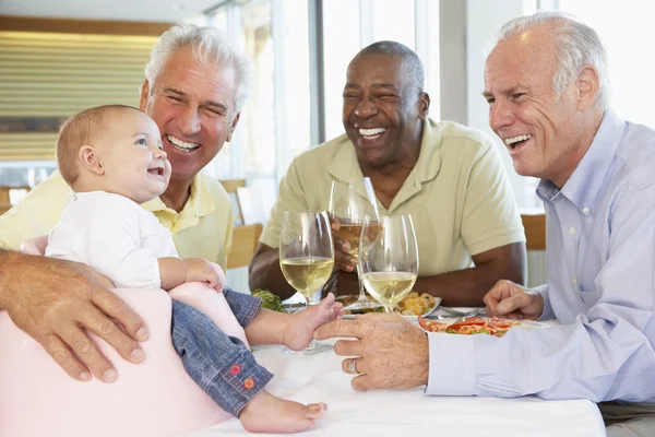 Мужчина показывает внучку друзьям в ресторане — стоковое фото