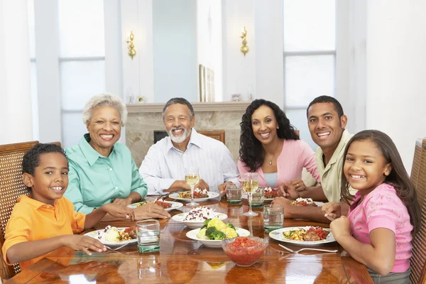 Семья, имеющая еду вместе дома — стоковое фото