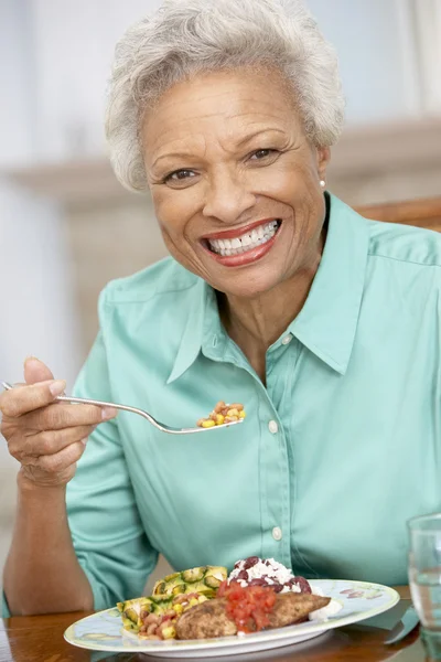 Mulher desfrutando de uma refeição em casa — Fotografia de Stock