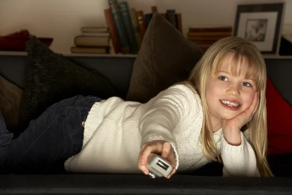年轻女孩使用电视遥控器 — 图库照片