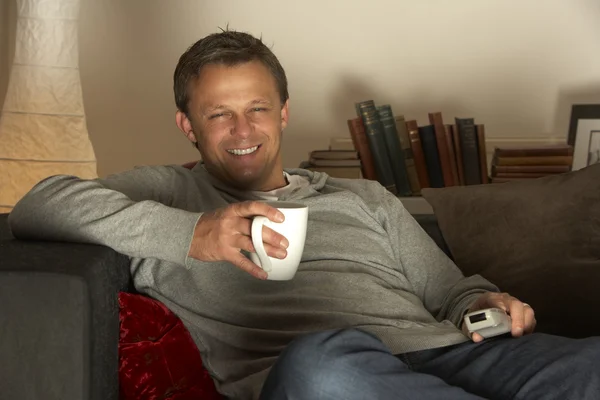 Mann entspannt sich bei Kaffee und Fernsehen — Stockfoto
