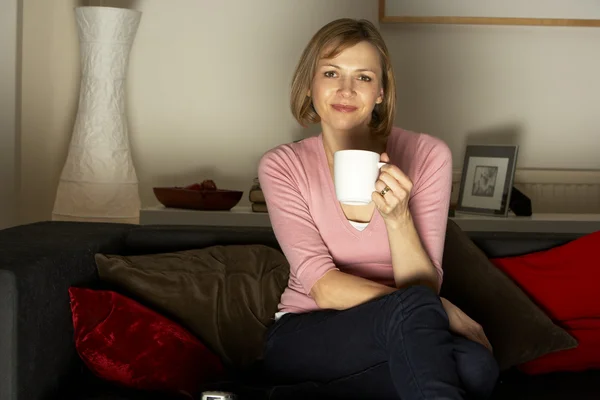 Kadın Televizyon Izlerken Kahve Bir Fincan Ile Rahatlatıcı — Stok fotoğraf