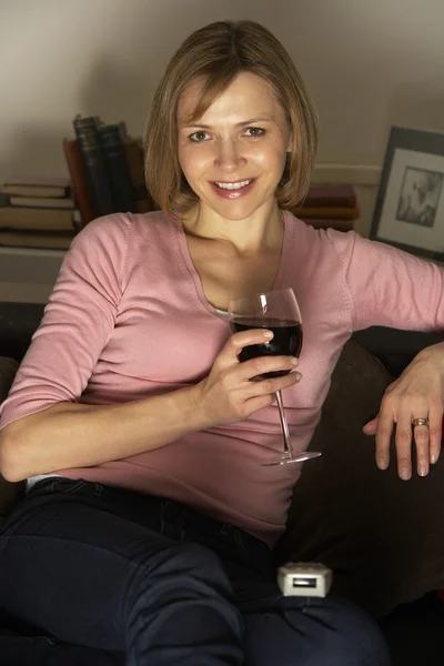 Žena se sklenicí vína, sledování televize — Stock fotografie