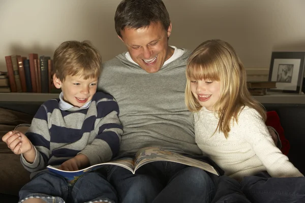父亲和两个孩子阅读 — 图库照片