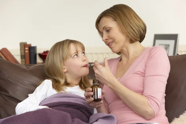Mãe dando remédio para a filha doente — Fotografia de Stock