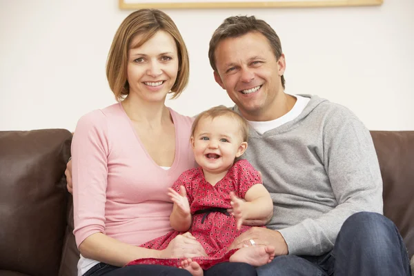 両親とソファの上の赤ん坊の娘 — ストック写真