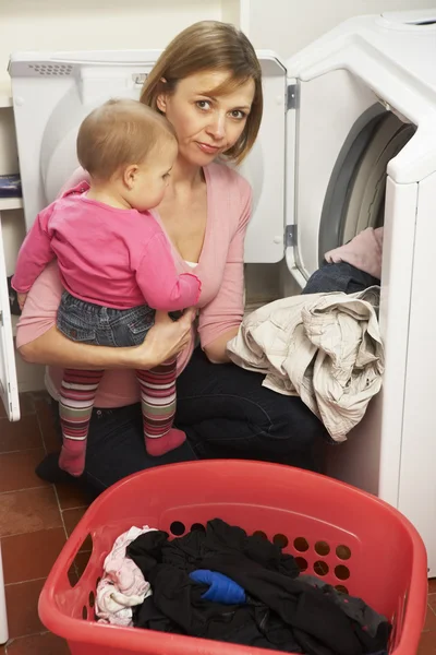 Frau Wäscht Wäsche Und Hält Kleine Tochter — Stockfoto