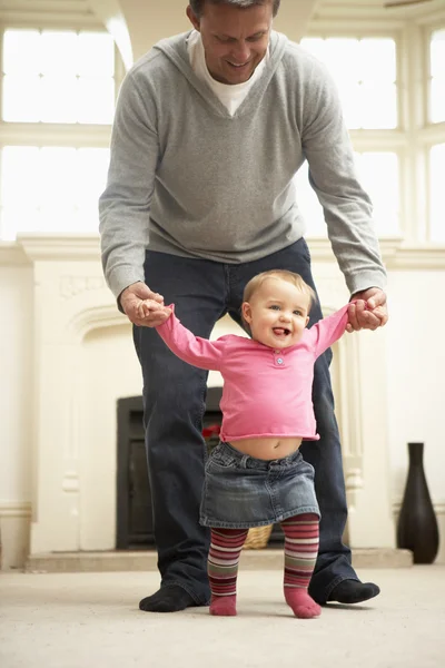 Vader helpt baby dochter wandelen — Stockfoto