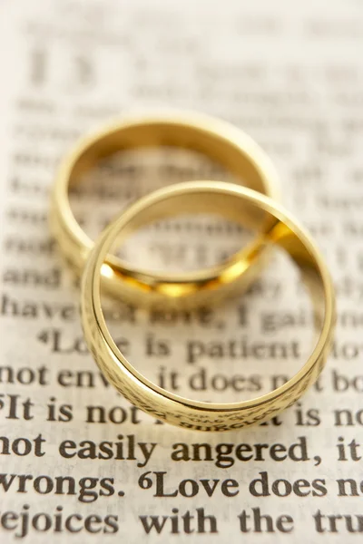 Deux anneaux de mariage reposant sur une page biblique — Photo