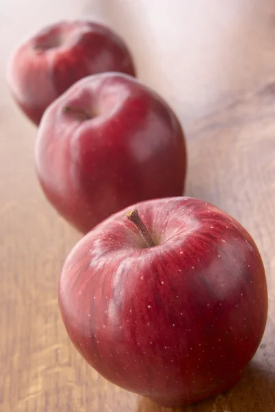 Čerstvá červená jablka sedí na lavičce — Stock fotografie