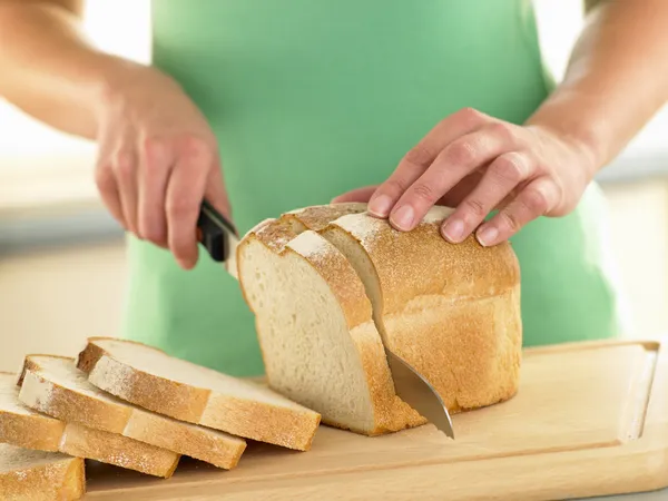 Frau Schneidet Einen Laib Weißbrot — Stockfoto