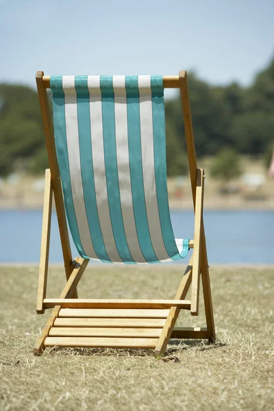 Sedia da spiaggia solitaria seduta accanto all'acqua — Foto Stock