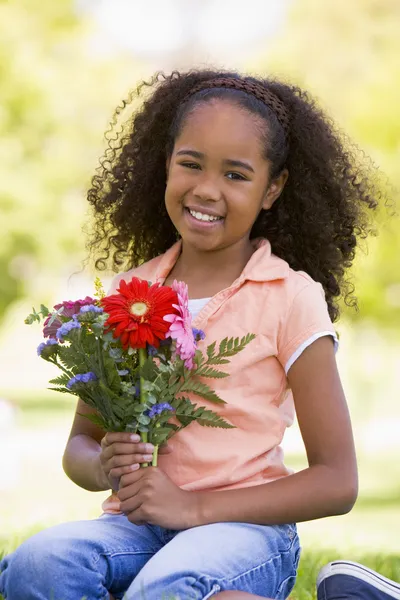 Gadis muda memegang bunga dan tersenyum Stok Lukisan  