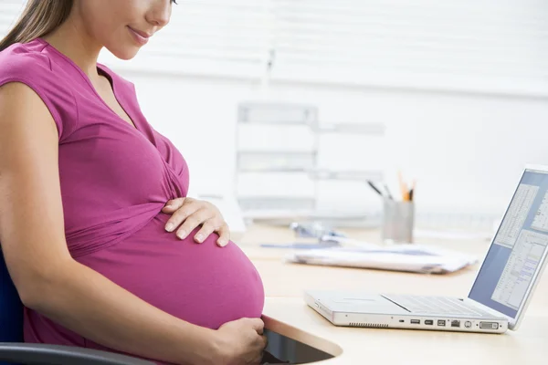 Pregnant woman at work Royalty Free Stock Photos
