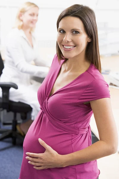 Pregnant woman at work Stock Image