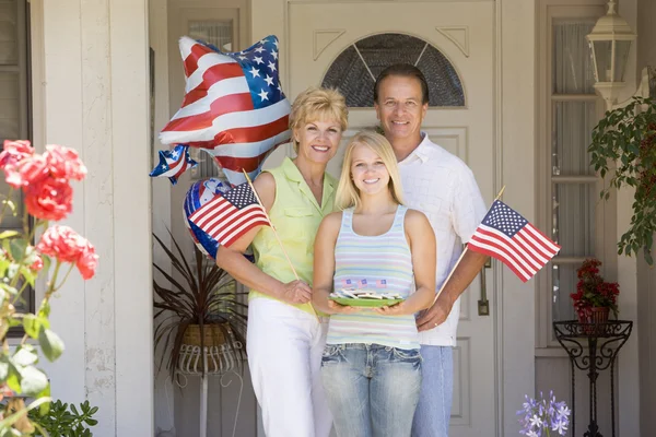 Familjen på ytterdörren fjärde juli med flaggor och cookies sm — Stockfoto