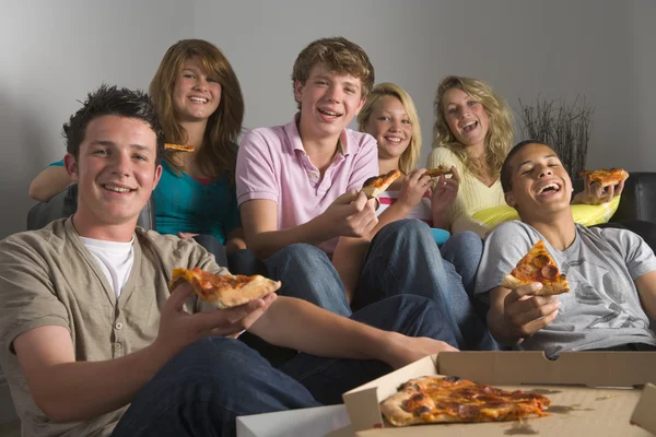 Tieners met plezier en eten van pizza Stockafbeelding