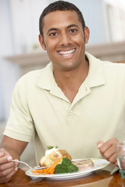 Hombre disfrutando de una comida en casa Imagen de archivo