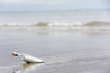 Message In A Bottle Buried In Sand On The Beach clipart