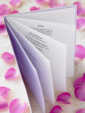 Wedding Booklet Surrounded By Rose Petals clipart