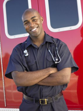 Portrait of paramedic in front of ambulance clipart