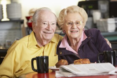 Senior couple having morning tea together clipart