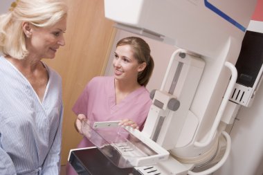 Nurse Assisting Patient About To Have A Mammogram clipart