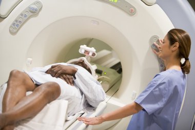 Nurse With Patient As They Prepare For A Computerized Axial Tomography (CAT) Scan clipart