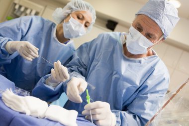 Surgeons Preparing Equipment For Surgery clipart