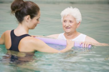 Instructor And Elderly Patient Undergoing Water Therapy clipart