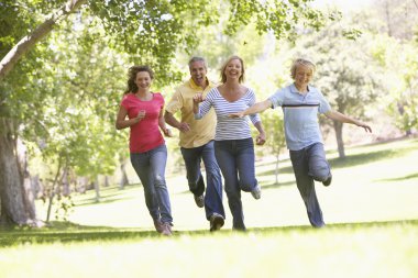 Family Running Through A Park clipart