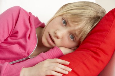 Young Girl Looking Sad On Sofa clipart