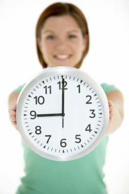 Woman Holding Clock Showing 9 O'Clock clipart