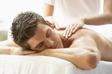 Young Man Enjoying Massage At Spa clipart