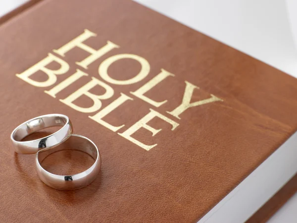 Vigselringar som vilar på en Bibeln — Stockfoto