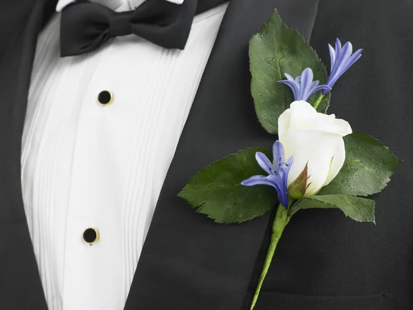 Человек в костюме с корсажем из белой розы — стоковое фото