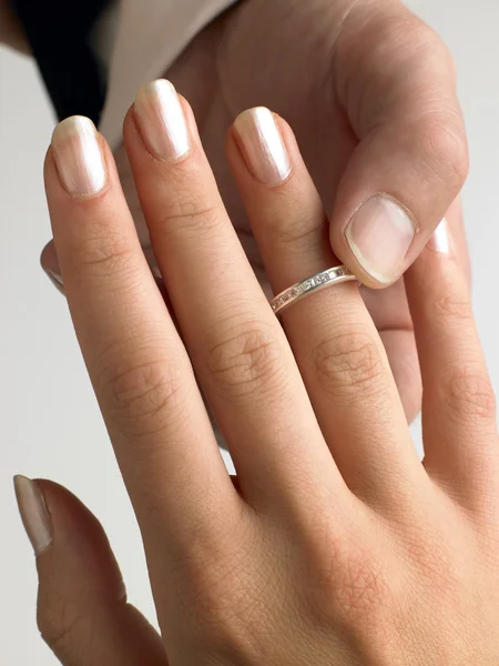 Мужчина надевает бриллиантовое кольцо на женский палец — стоковое фото