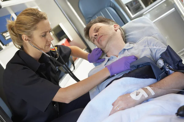 Paramédico que atende paciente em ambulância — Fotografia de Stock