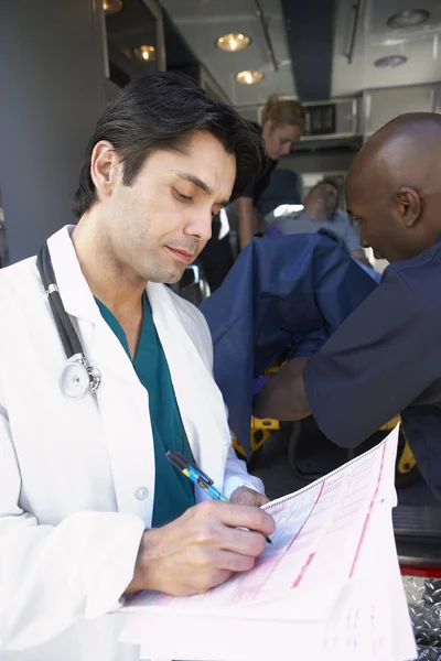 Doctor Taking Notes Paramedics Unload Patient — Stock Photo, Image