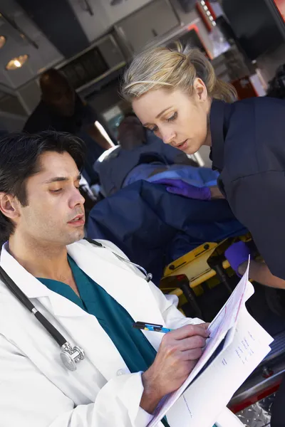Paramedico consigliare medico circa il paziente in arrivo — Foto Stock