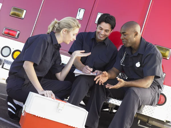Três Paramédicos Conversando Fazendo Papelada Sentados Lado Seus — Fotografia de Stock