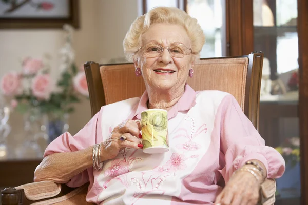 Starší žena pití horké nápoje — Stock fotografie