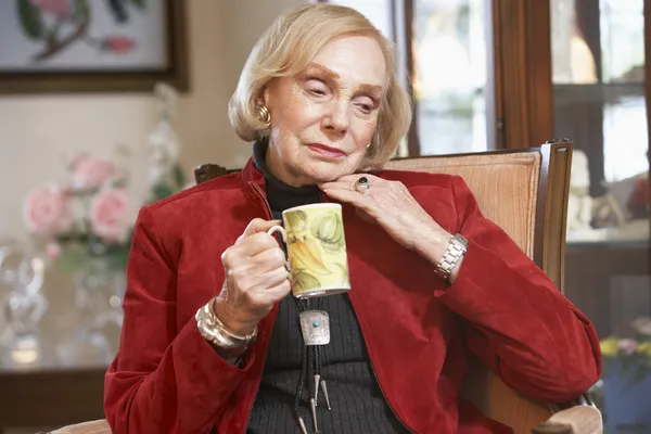 stock image Senior woman drinking hot beverage