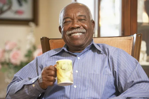 Старший мужчина пьет горячий напиток — стоковое фото